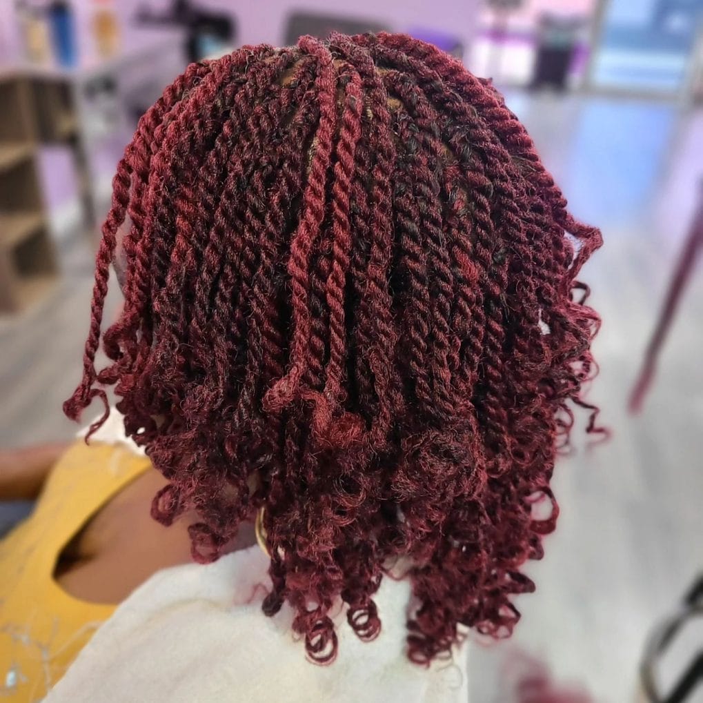 Short, bold red wine kinky twists with curled ends above shoulders