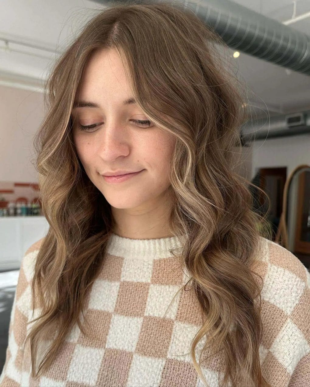 Relaxed waves with sun-faded balayage and ash-blonde highlights on hair.