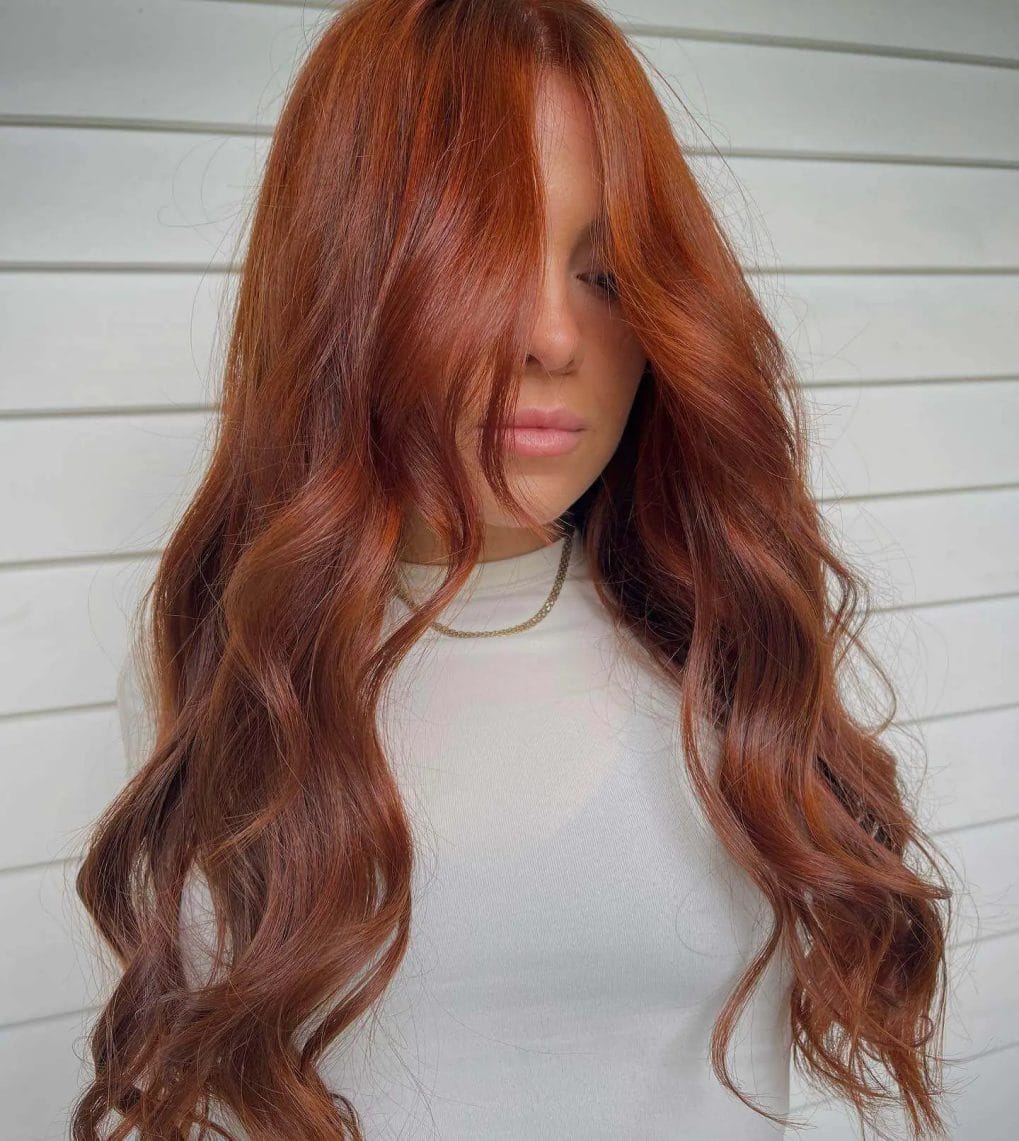 Rich, fiery copper hair in luxurious waves with gentle layering.