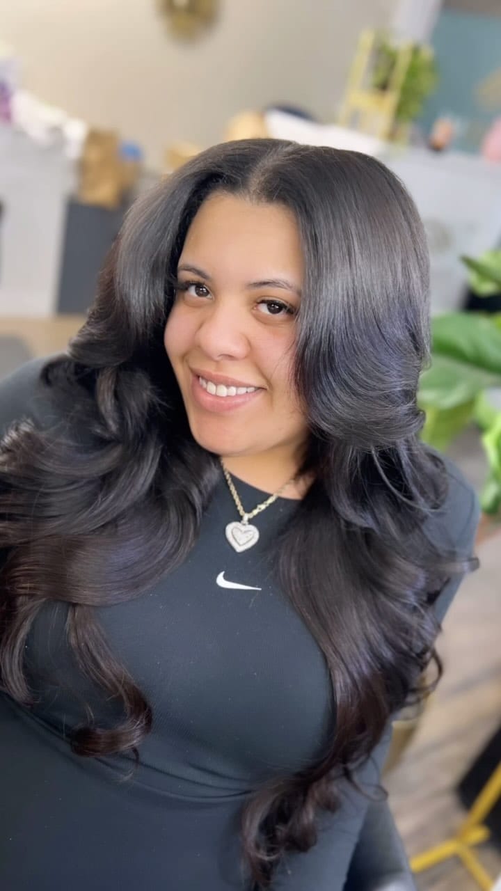 Romantic silk press with flowing waves, side part, and rich brown tones draping over one shoulder