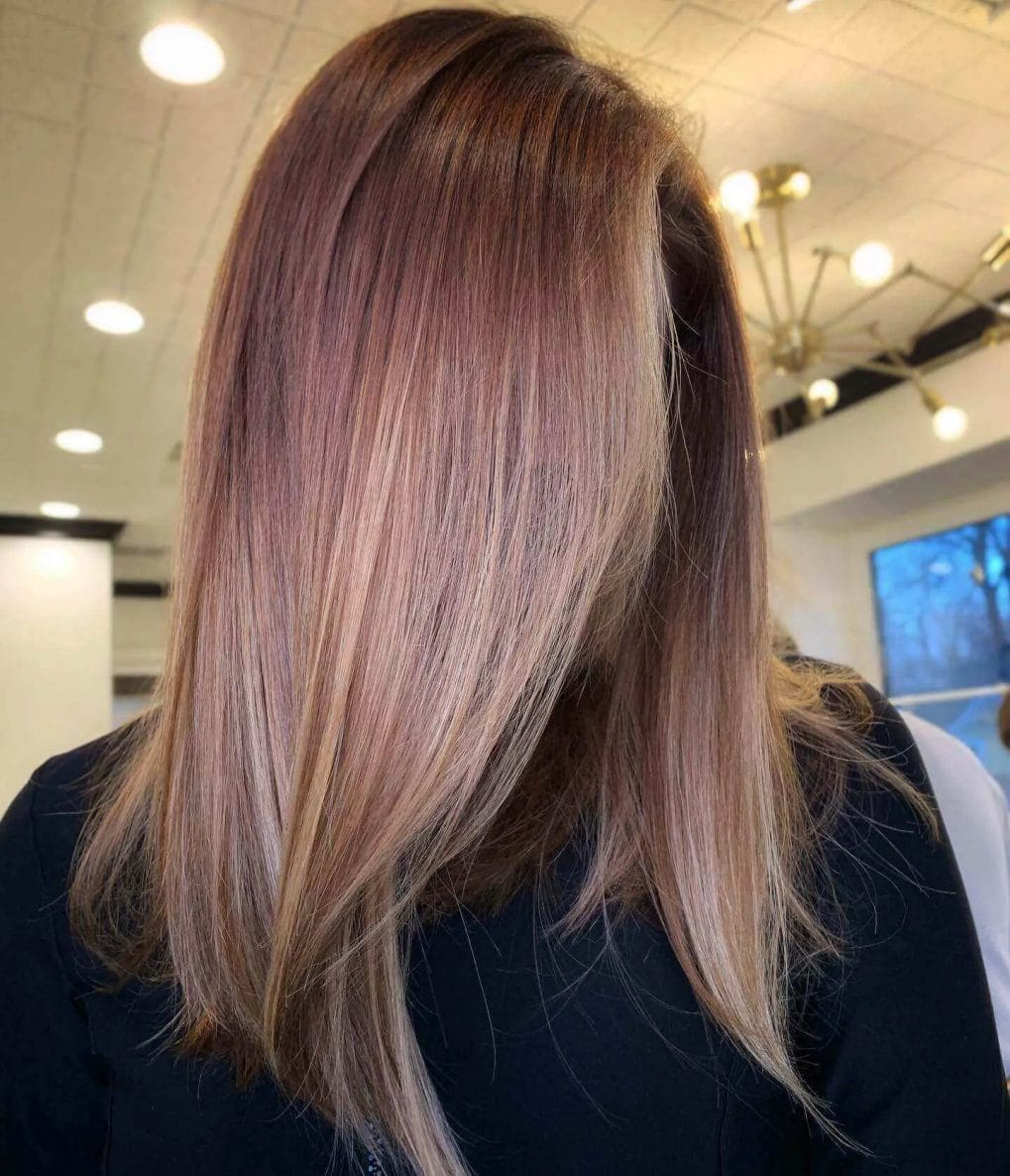 Mid-length straight hair with rose gold balayage and subtle layers.