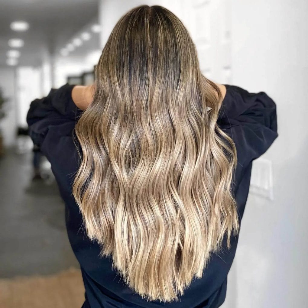 Sandy blond hair in a V-shape, highlighted with balayage technique.