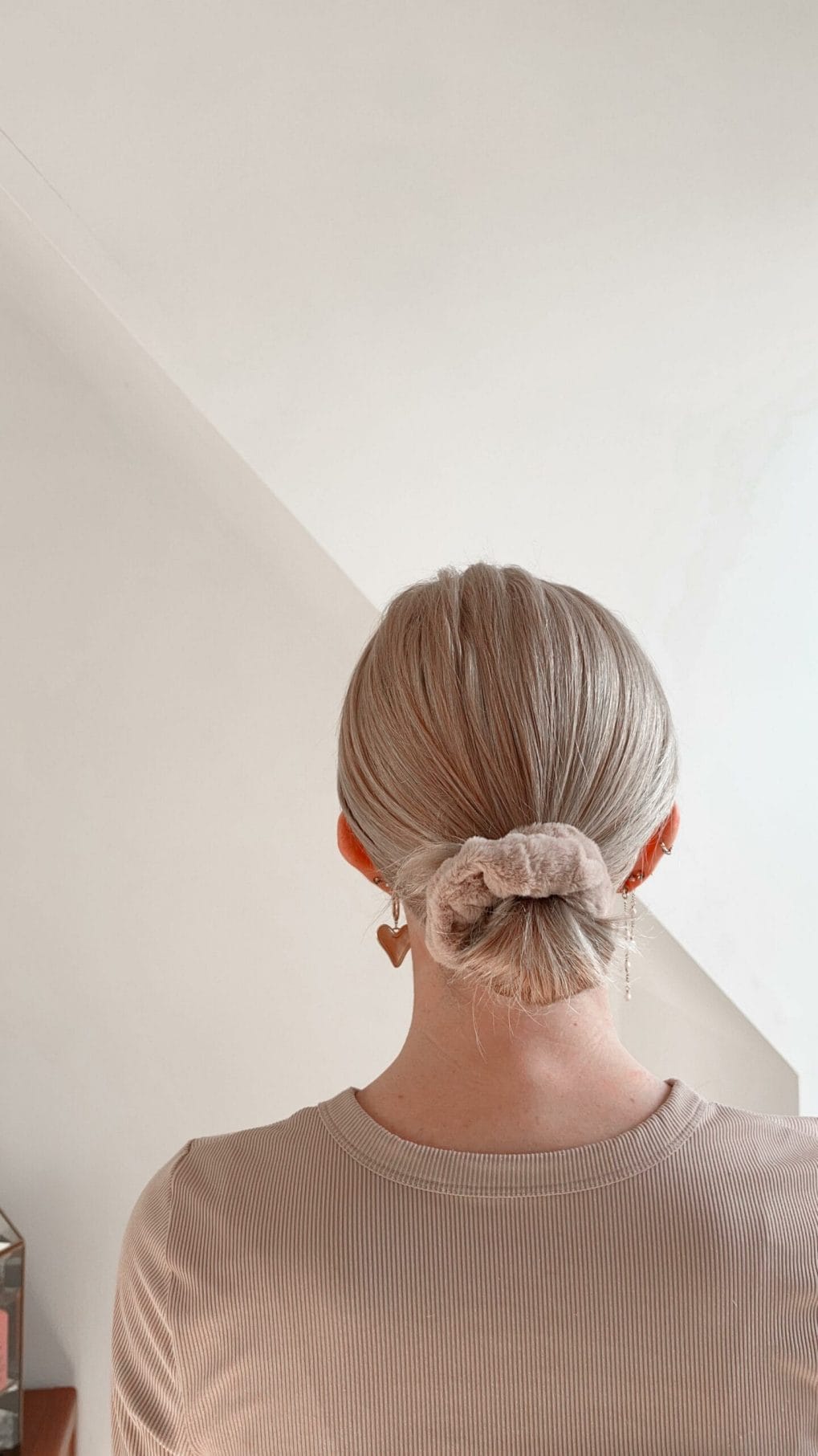 Sandy blonde low bun with a cute scrunchie, a simple gym hairstyle solution