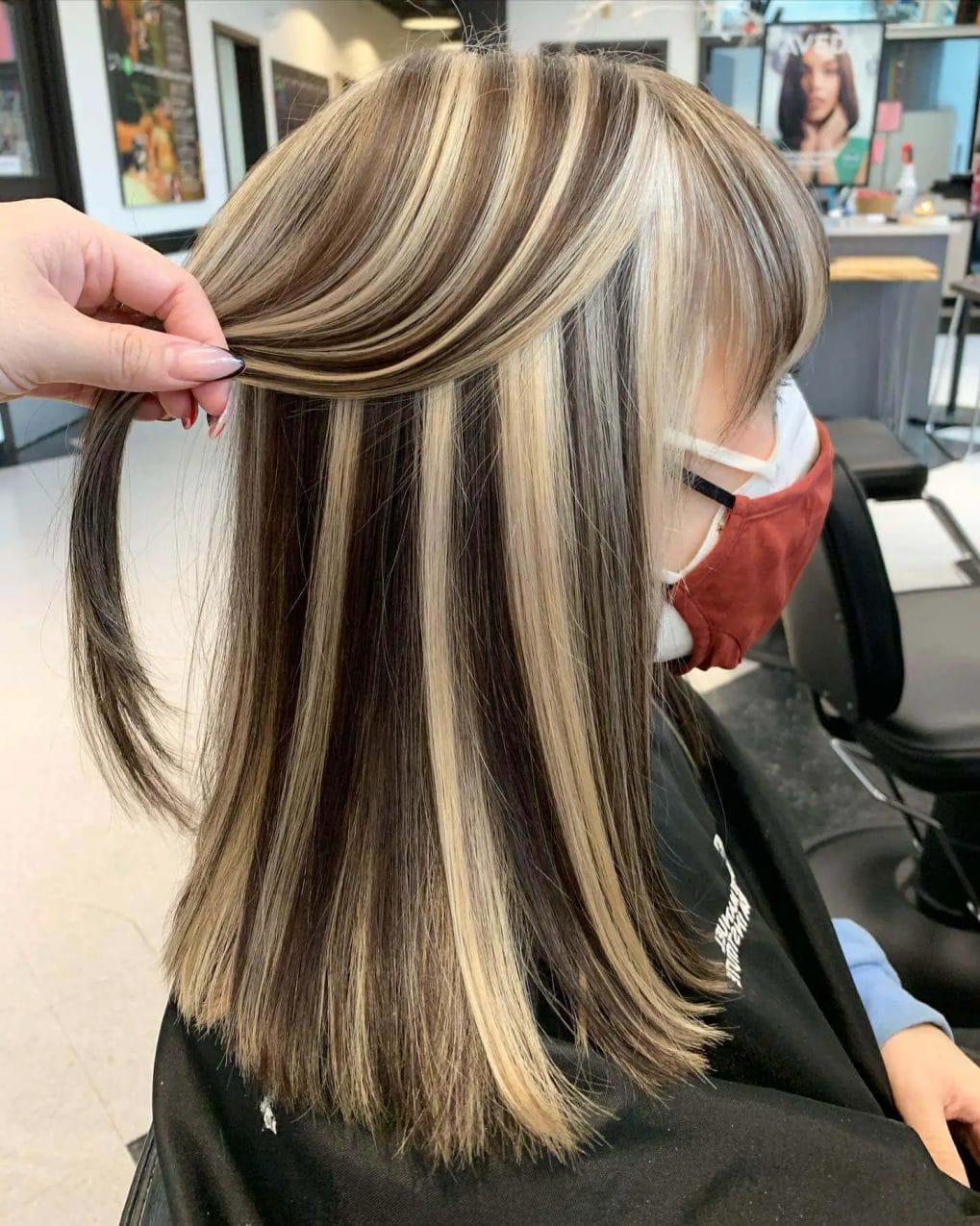 Mid-length cut with sandy blonde and light brown highlights against darker base.