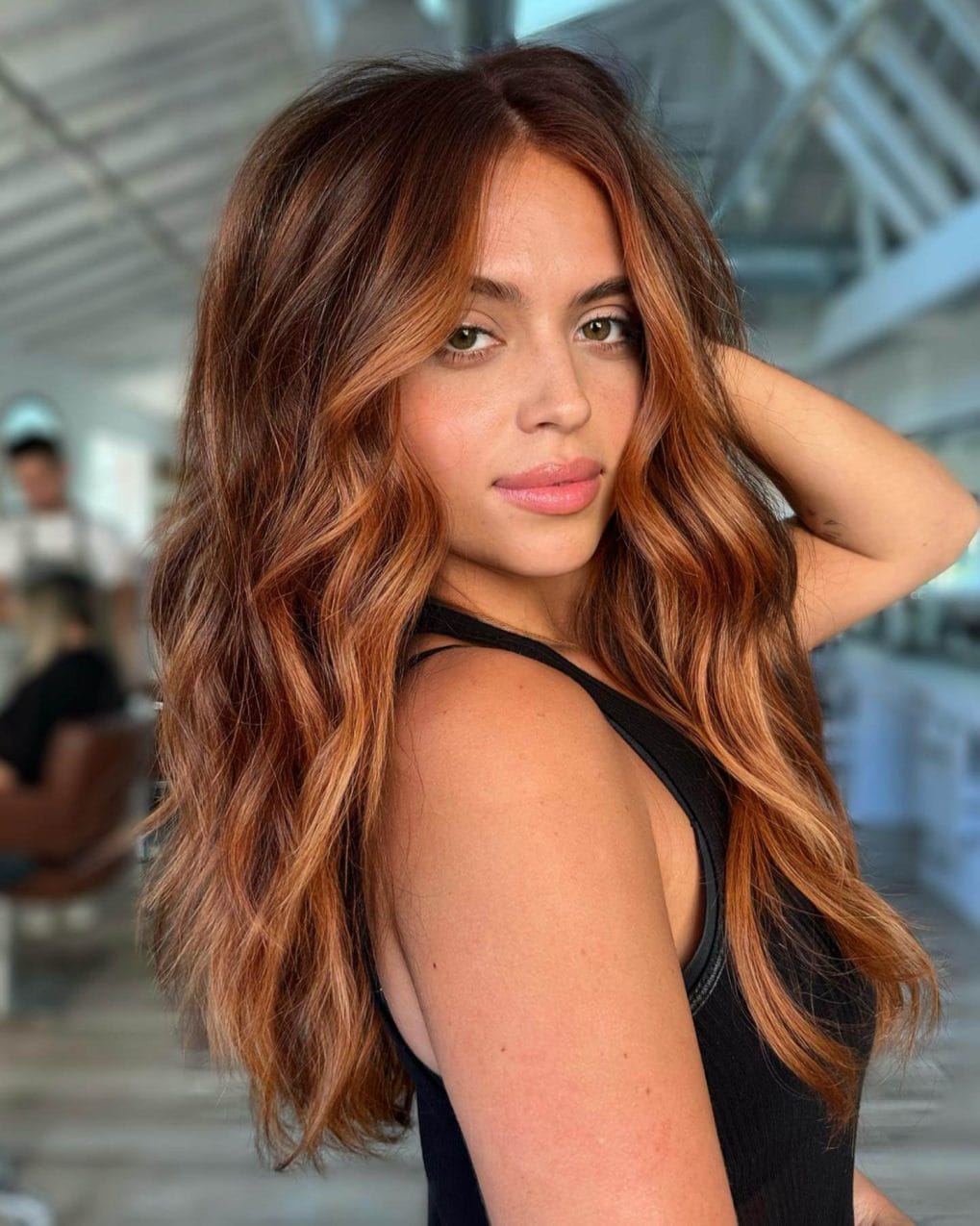 Shadow root copper hair with long layers and face-framing waves.