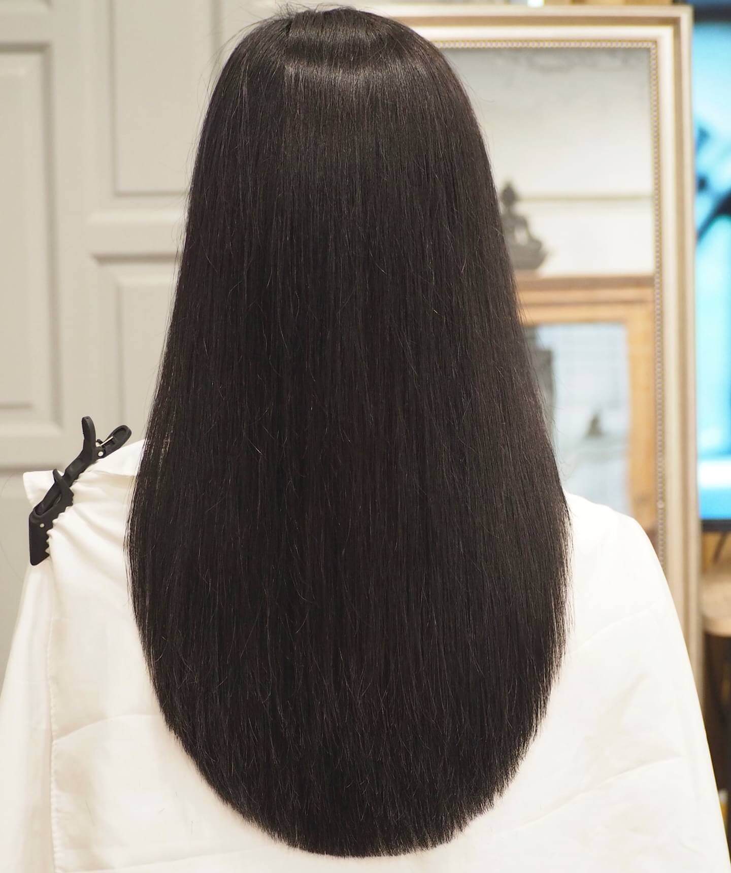 Shimmering raven-black sleek U-shaped haircut flowing seamlessly.
