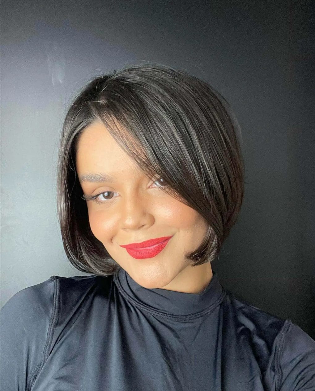 Shiny black '90s bob with inward curve and elegant side parting