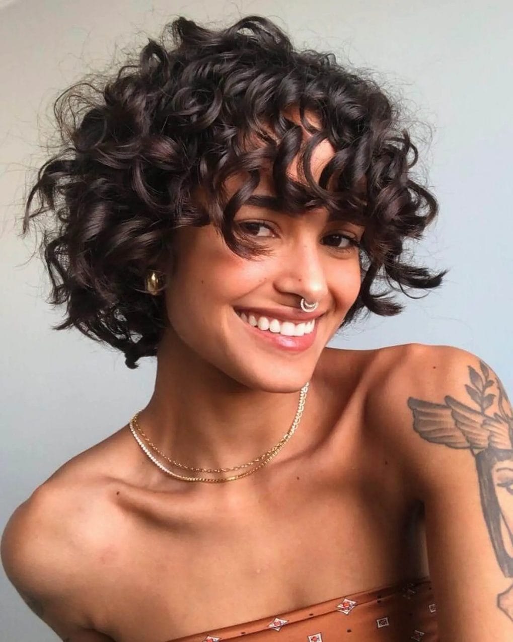 Short hairstyle with voluminous, tight perm curls.