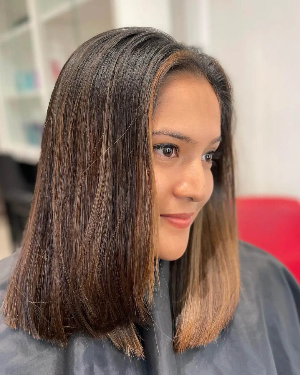 Straight shoulder-length hair with caramel gradient highlights.
