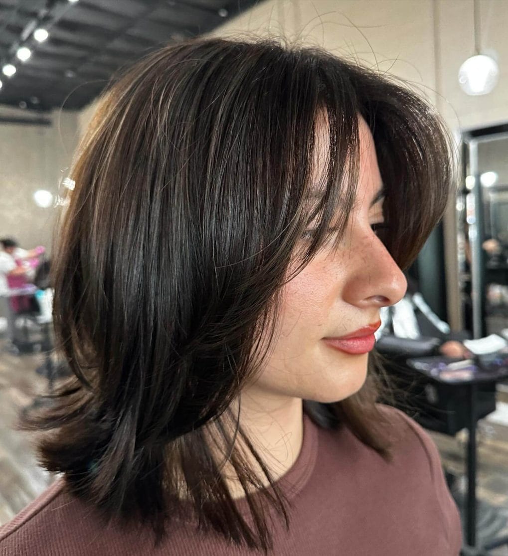 Shoulder-length layers with stylish 90s curtain bangs