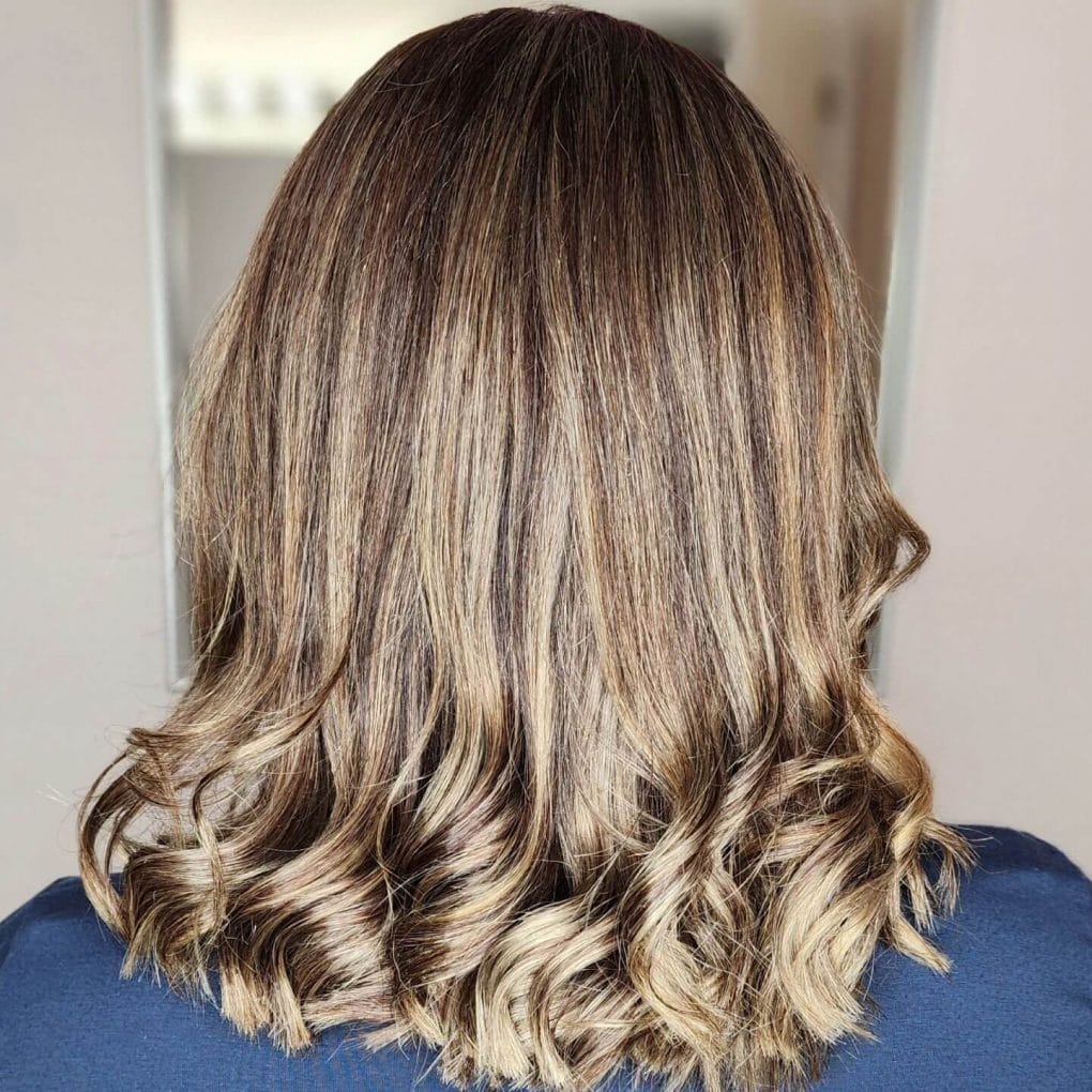 Shoulder-length wavy hair with warm blonde and brown balayage