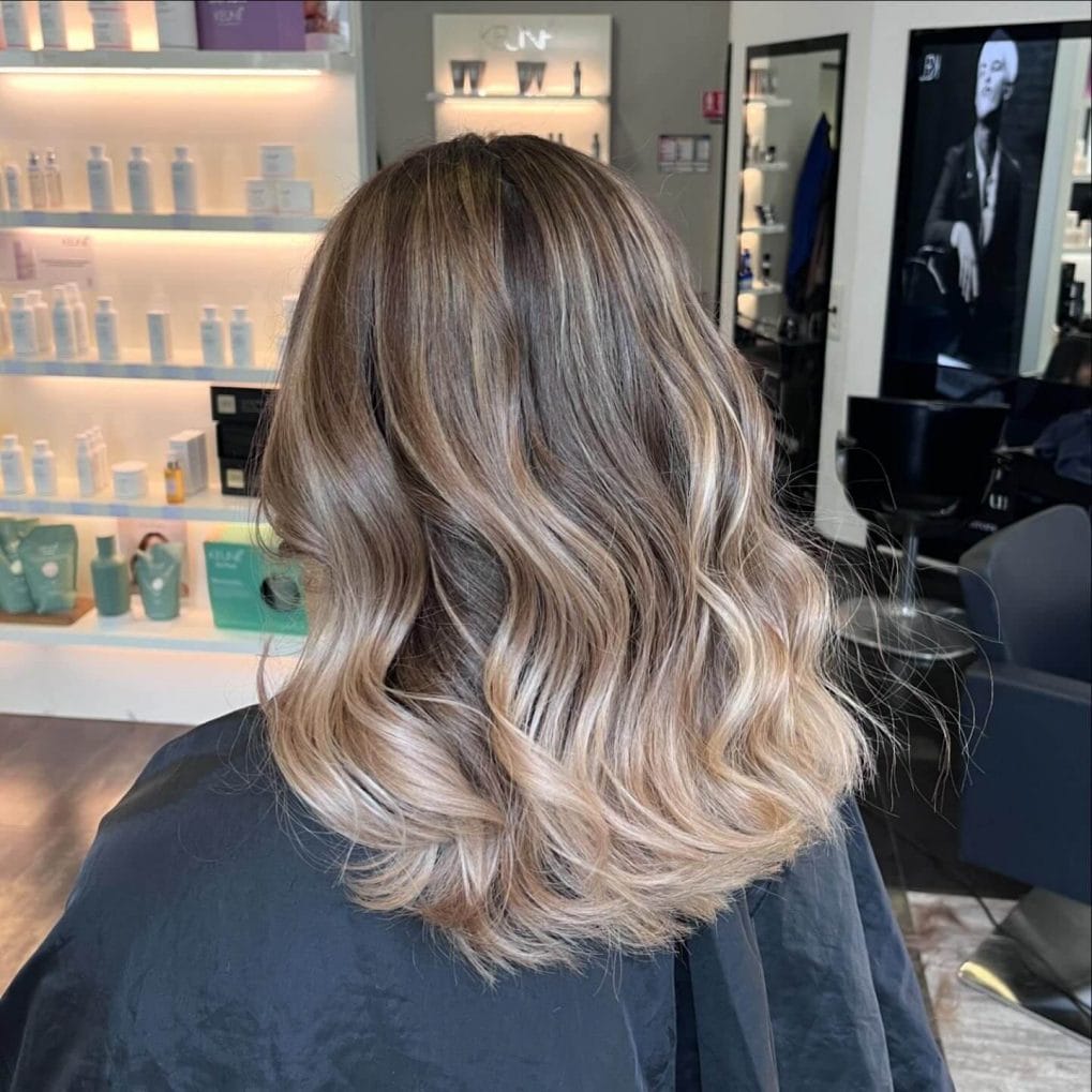 Shoulder-length wavy hair with warm brown and blonde balayage