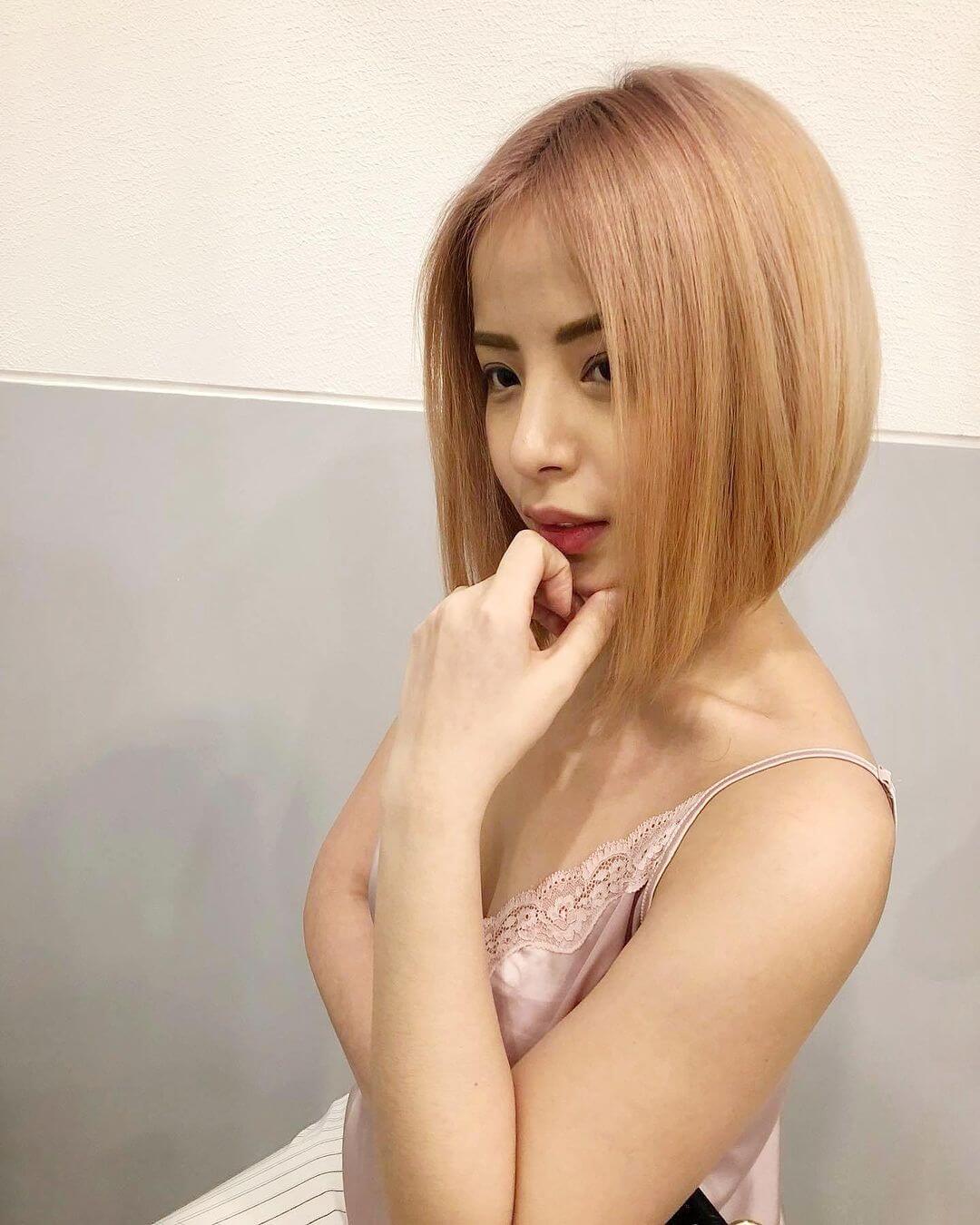 Straight shoulder-skimming bob in pastel peach with subtle layers.