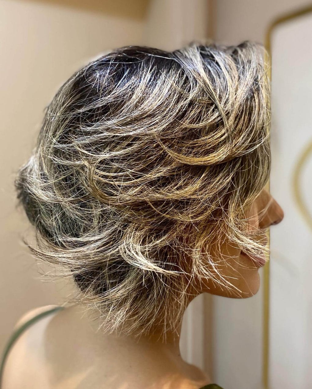 Longer pixie in brunette with golden blonde highlights and a side fringe.