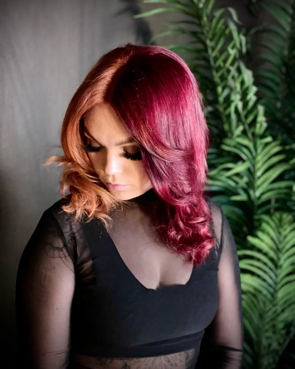 Side-parted hair with burgundy-copper split and soft waves