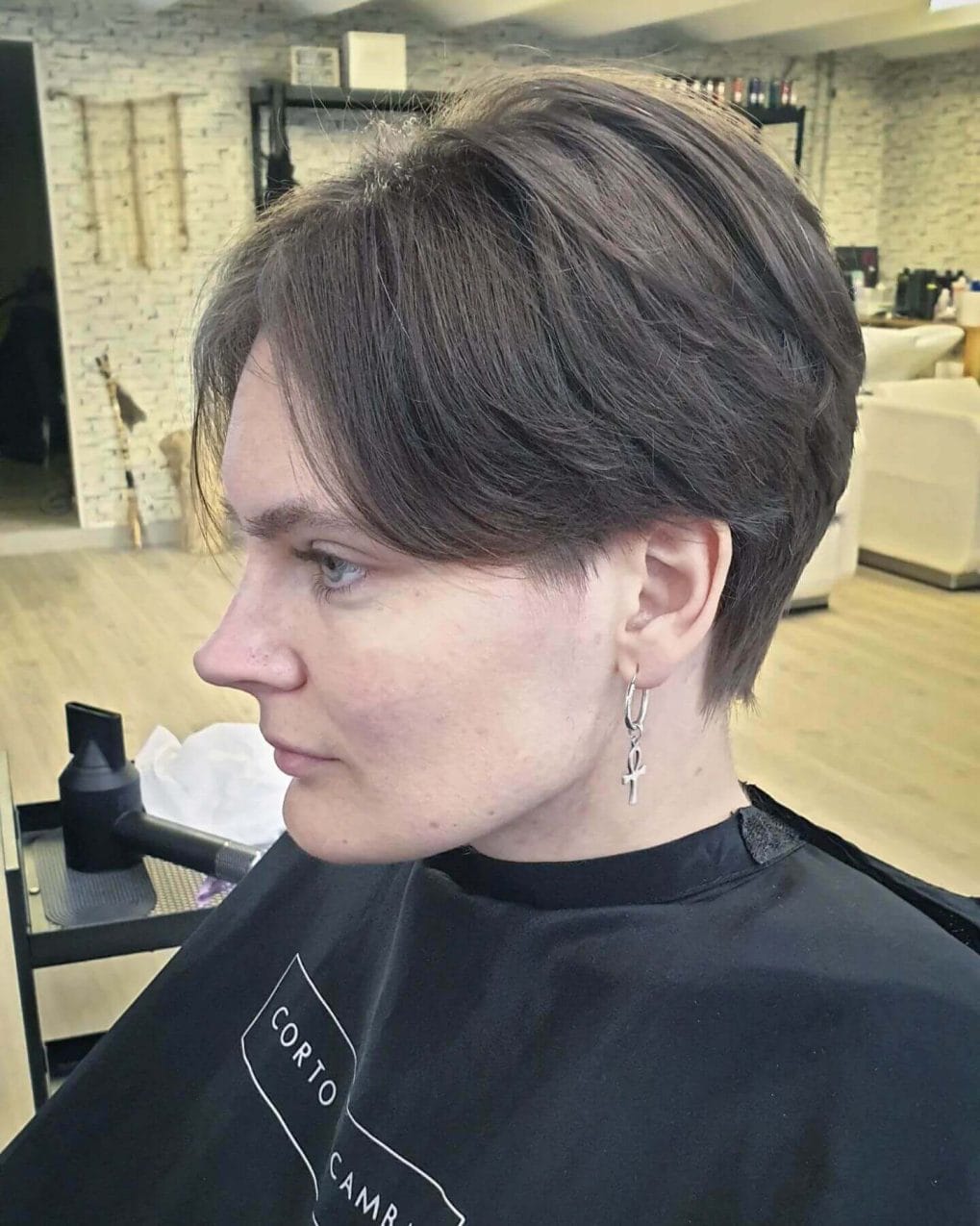 Modern mushroom cut with soft side-swept fringe and layered texture in rich brown.
