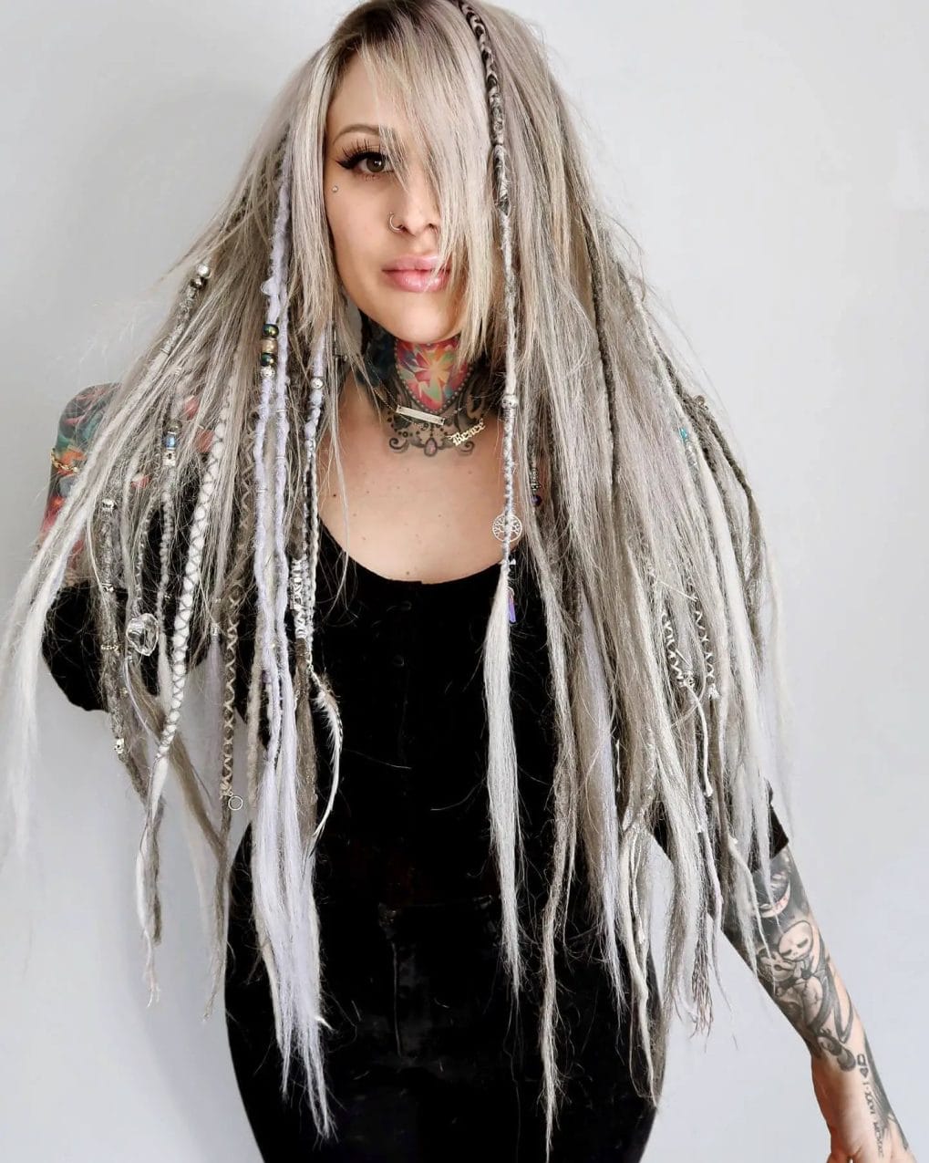 Silver ash base with textured synthetic dreadlocks and beads, paired with sleek bangs for an avant-garde festival style.