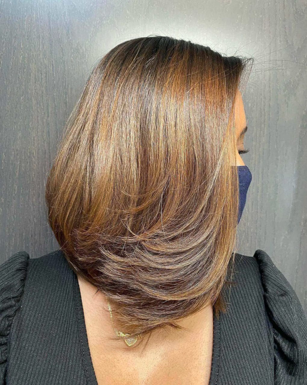 Sleek brown bob with golden highlights and a silky straight texture.