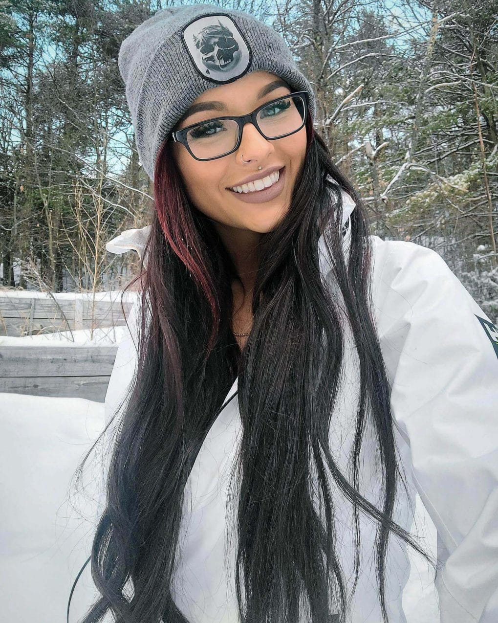 Sleek deep burgundy ombre straight hair peeking from beneath a beanie.