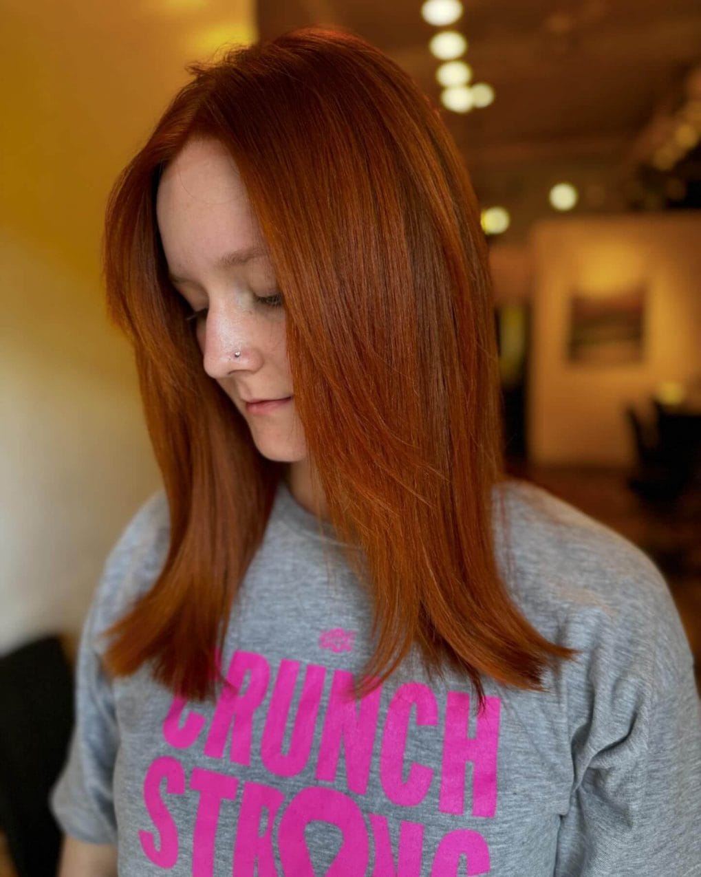 Sleek copper hair with subtle layers and center part
