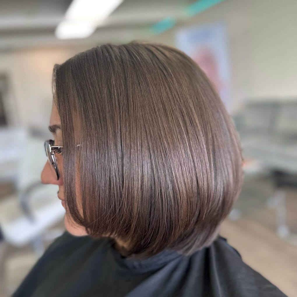 Sleek and full-bodied layered bob for thick hair in a rich brown color.

