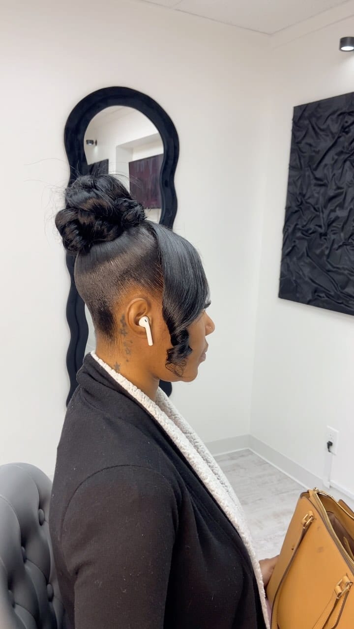 Sleek high bun with smoothly waved bangs