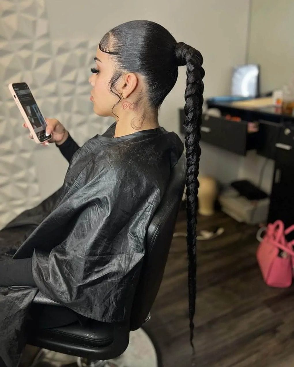 Sleek, polished, long black braid forming a ponytail down to the lower back.