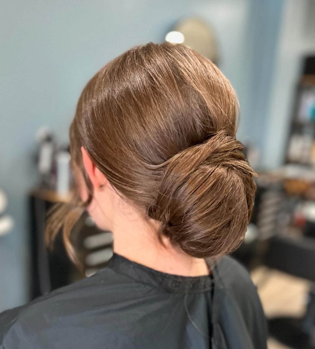 Sleek low chignon bun with smooth light brown hair