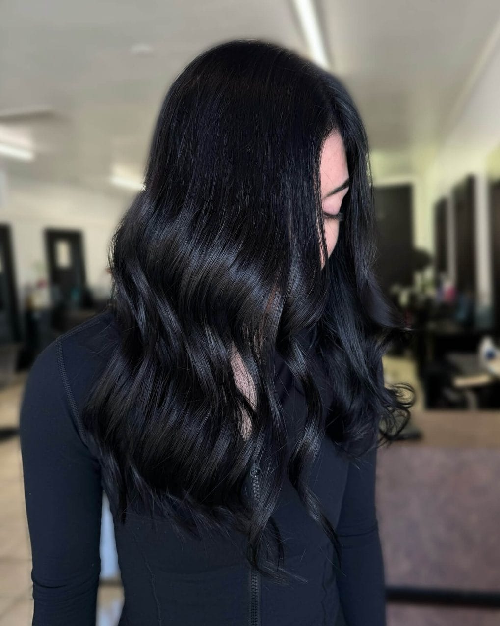 Sleek, polished raven-black hair with soft elegant waves