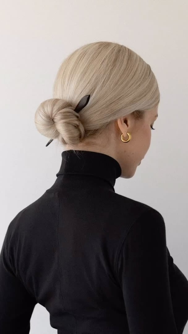 Sleek summer updo secured with a hair stick for cool elegance