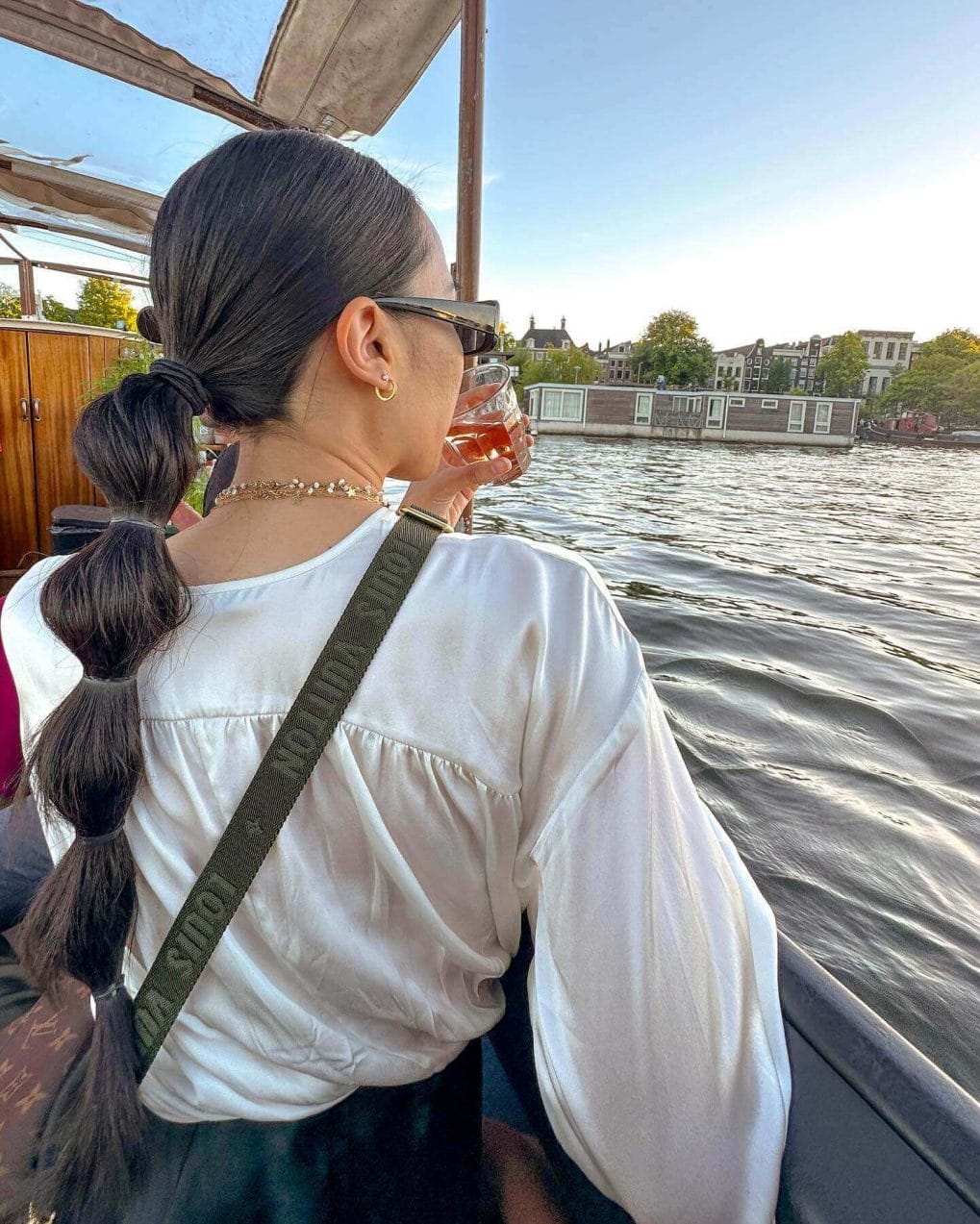 Low, loose ponytail in dark hair slicked back for softball elegance