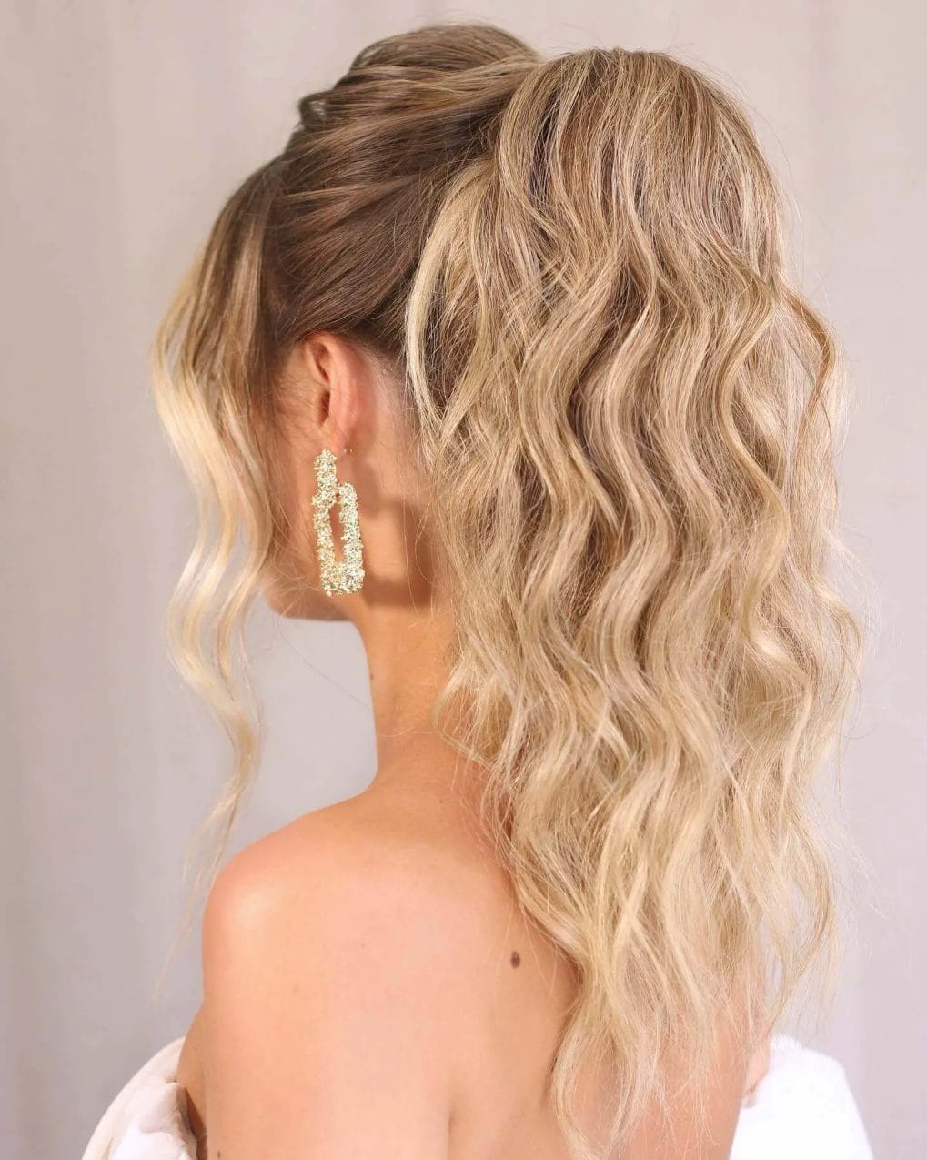 Long flowing waves with a sun-kissed half-back twist for a relaxed and chic birthday hairstyle.