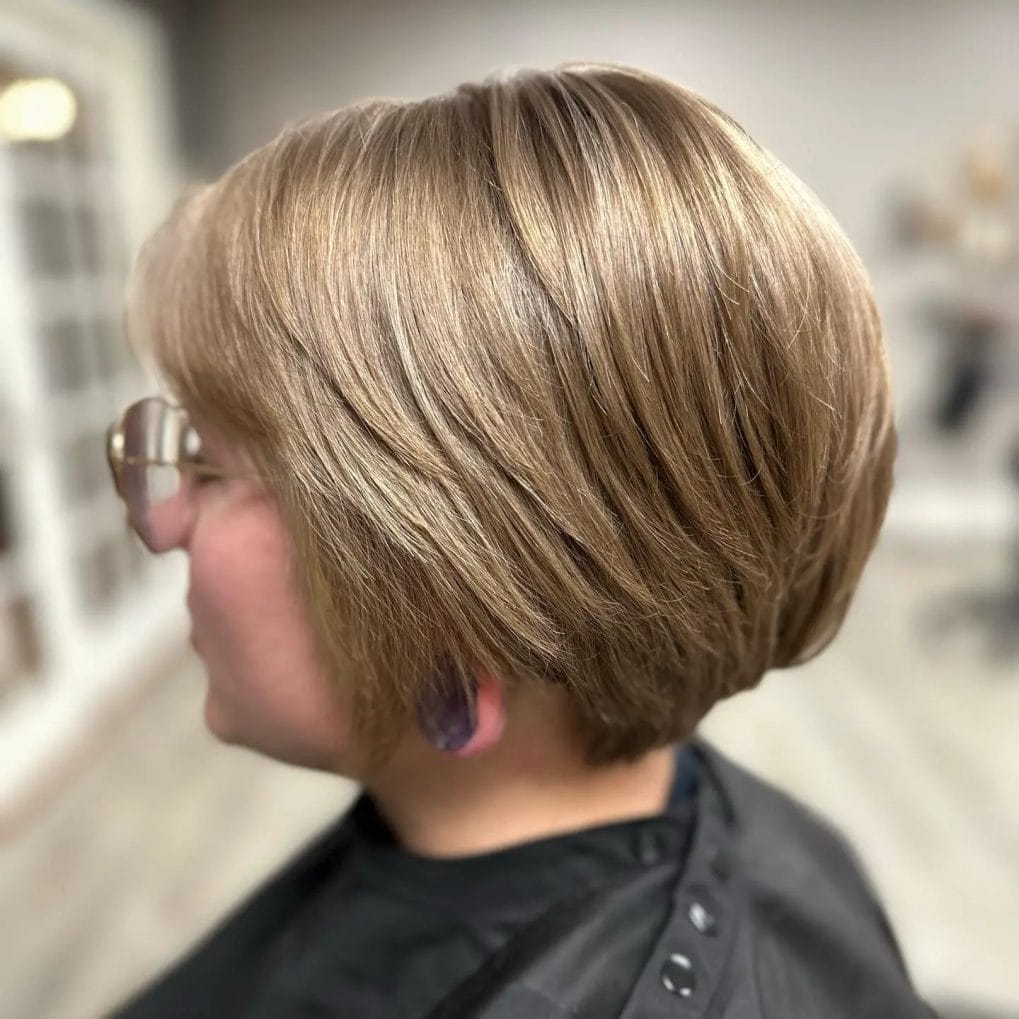 Warm brown and blonde mixed pixie bob with a soft, rounded silhouette and gentle side sweep