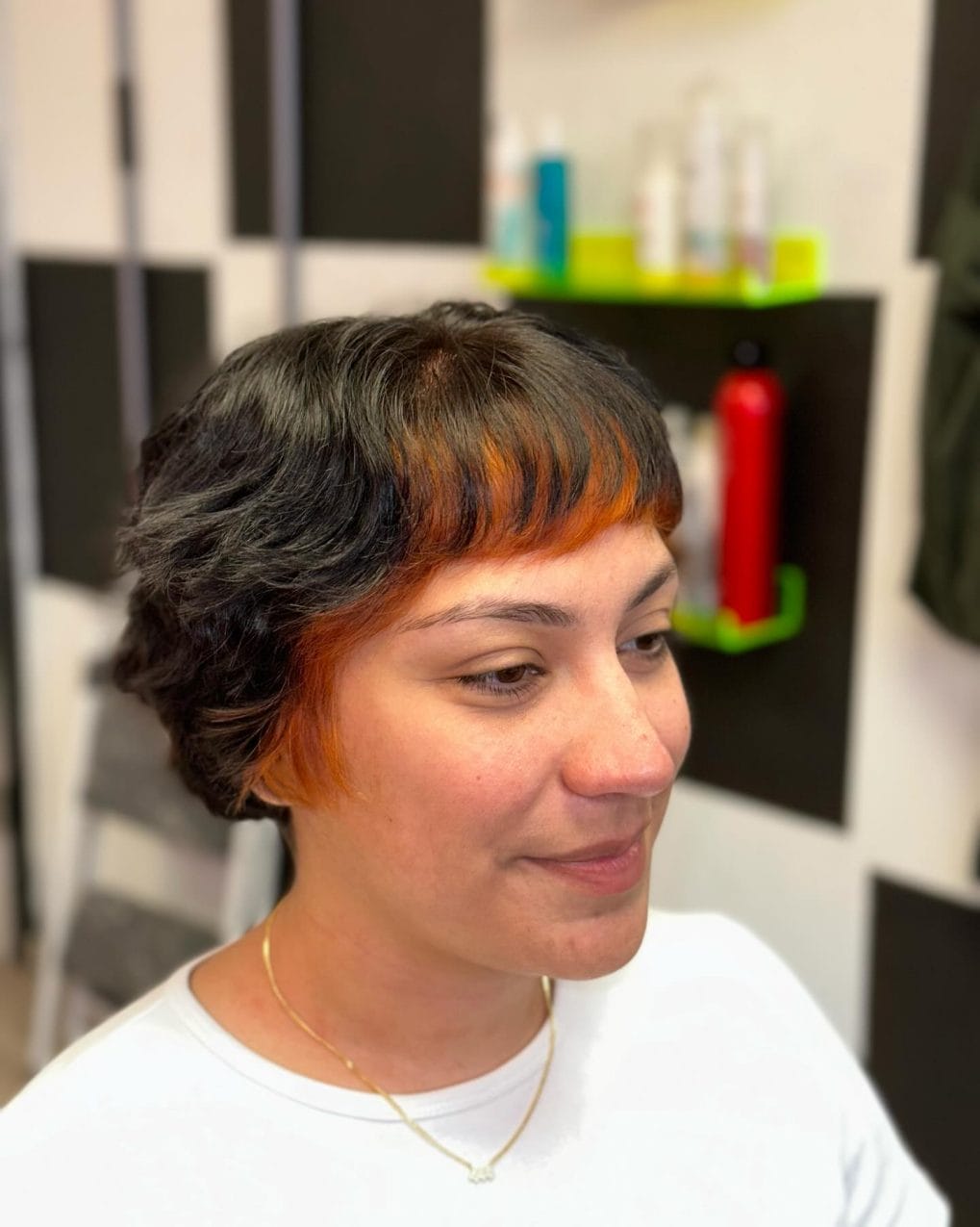Short cut with bold orange streaks and soft curls