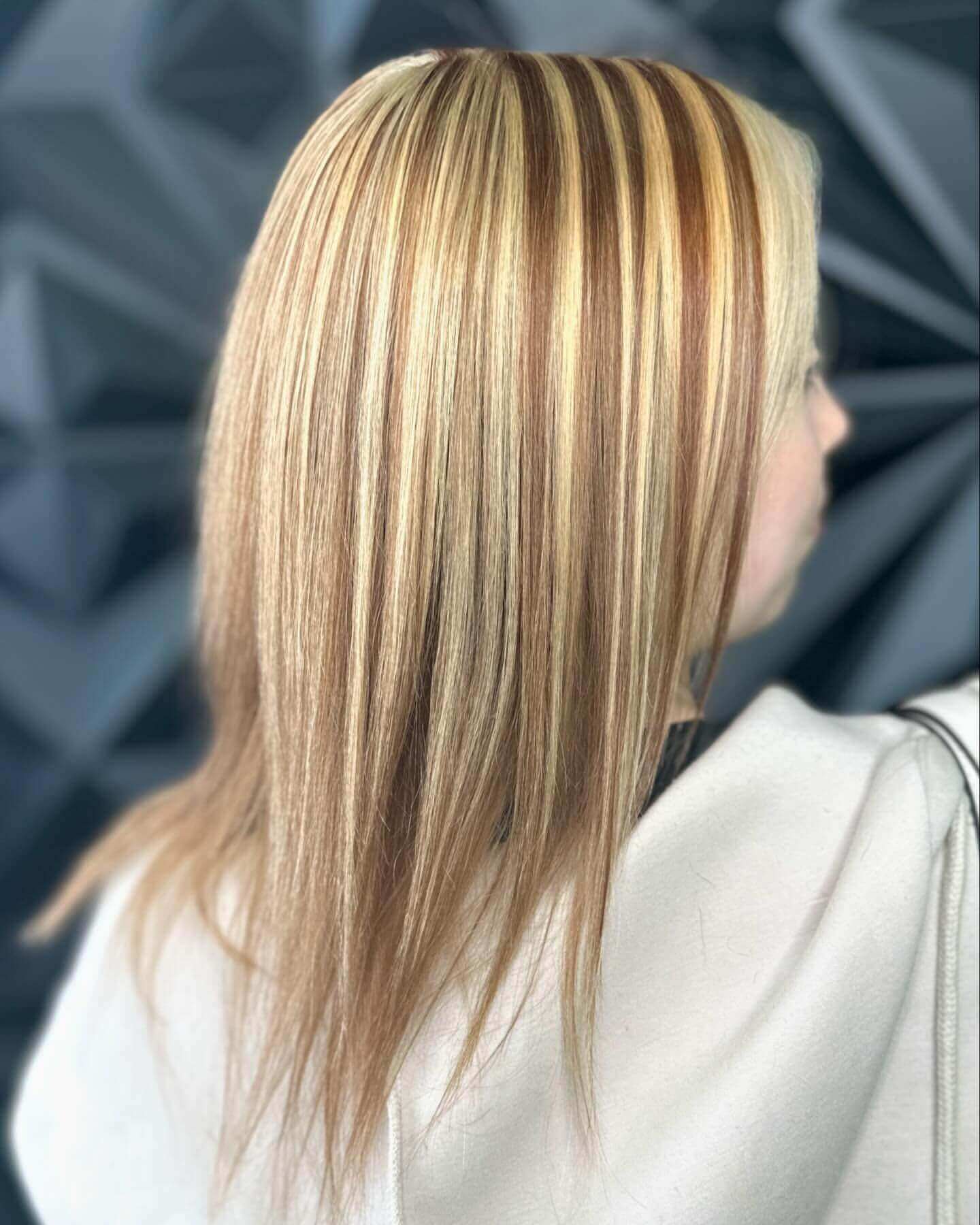 Straight long hair with blonde and light brown chunky highlights for a polished look