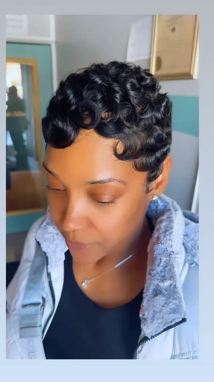 Sophisticated pixie with styled curls and glossy deep black hue