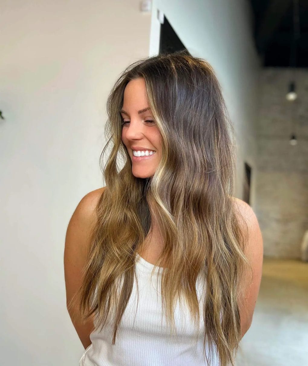 Sun-kissed balayage with chocolate roots and golden honey lengths on hair.