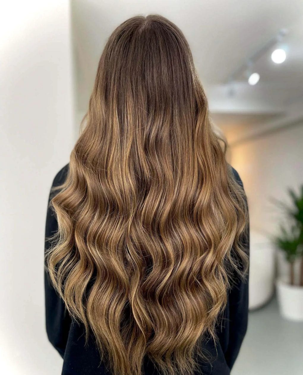 Sun-kissed balayage on flowing brunette hair.