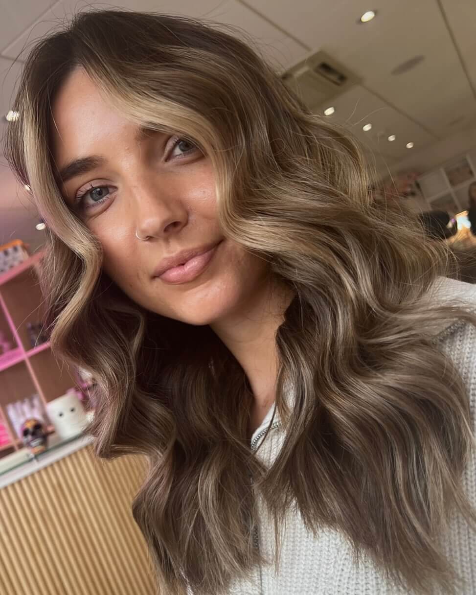 Sun-kissed balayage tones with soft, face-framing layers for a sophisticated winter style.