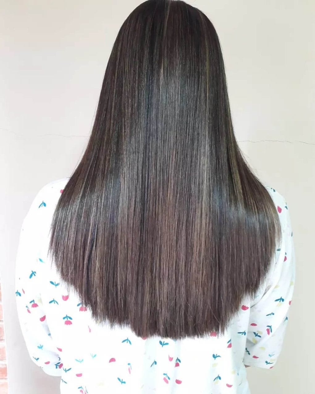 U-shaped brunette hair with sun-kissed balayage highlights and natural root gradation.