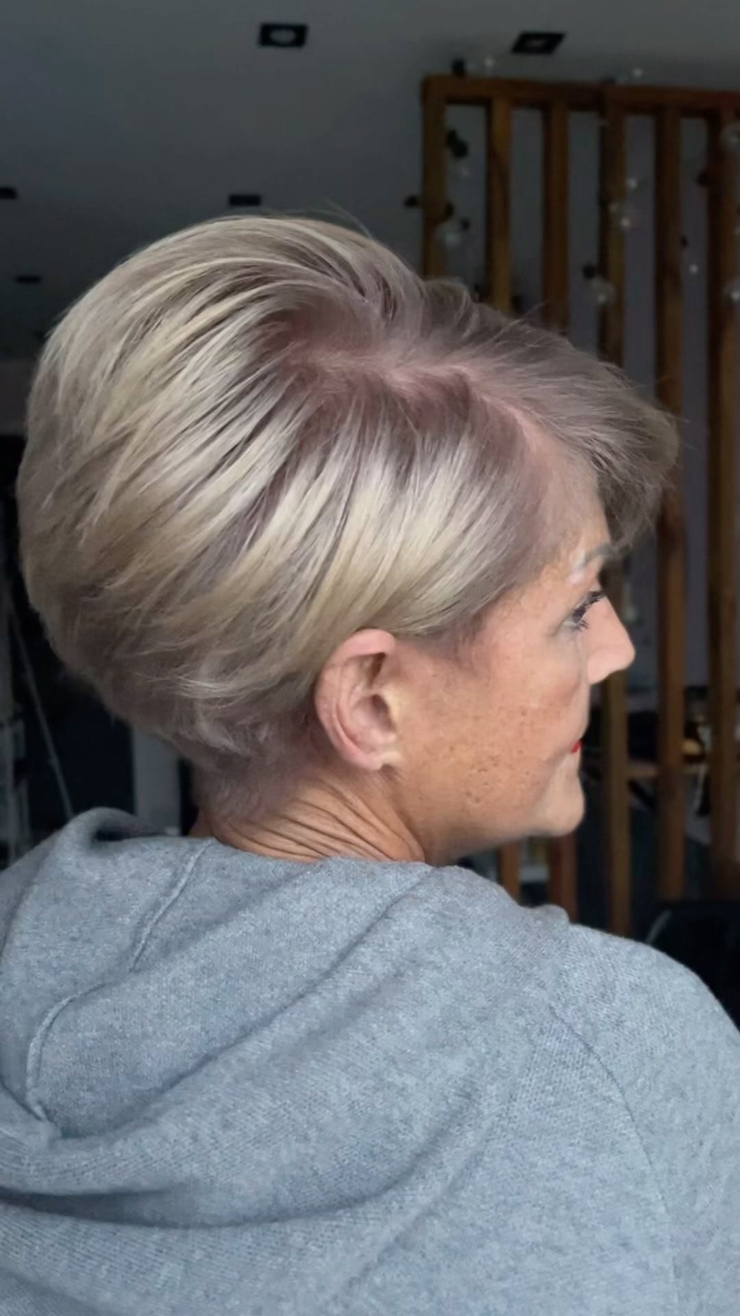 Trendy sun-kissed blonde pixie bob with darker roots and beautifully curved layers
