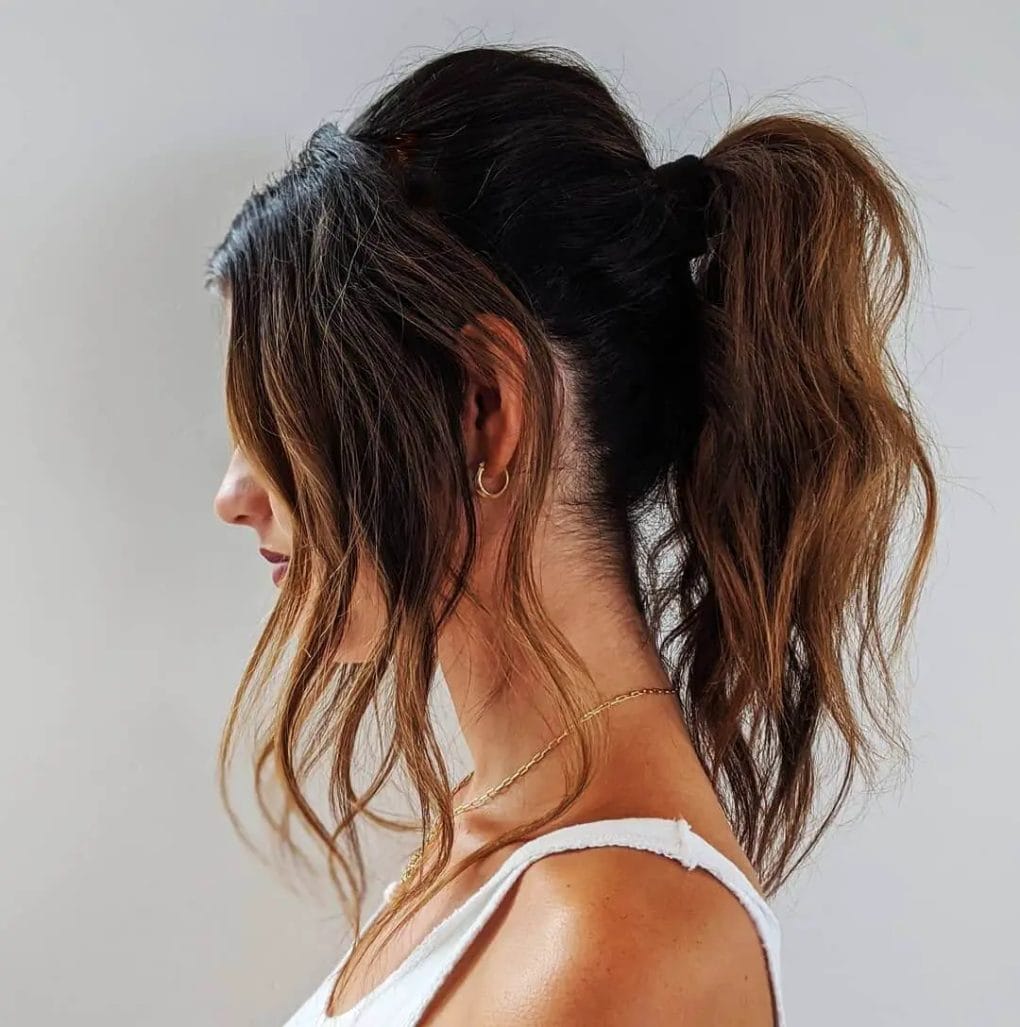 Effortlessly chic tousled brown ponytail with natural waves and a sun-kissed, relaxed look.