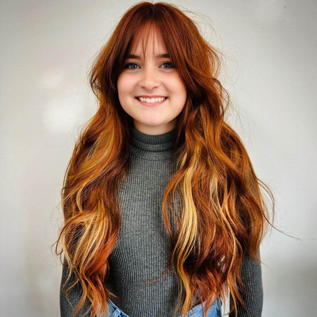 Sun-kissed copper hair with playful wispy bangs