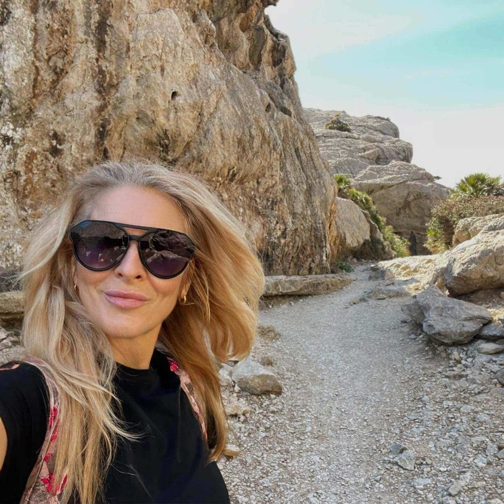 Blonde hiker's hair in soft waves catching sunlight on mountain trail