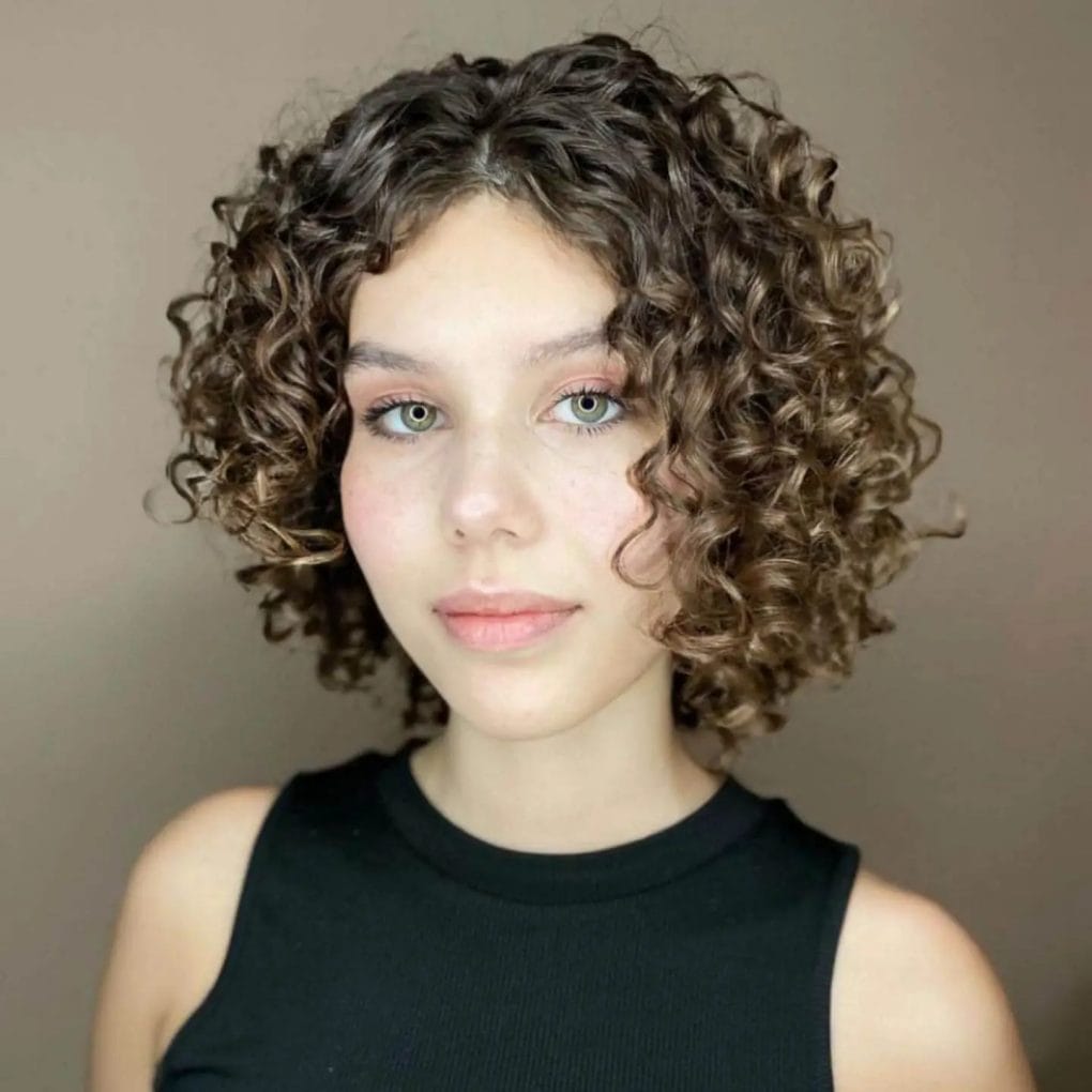 Medium to short length hair with tight, symmetrically framed curls.