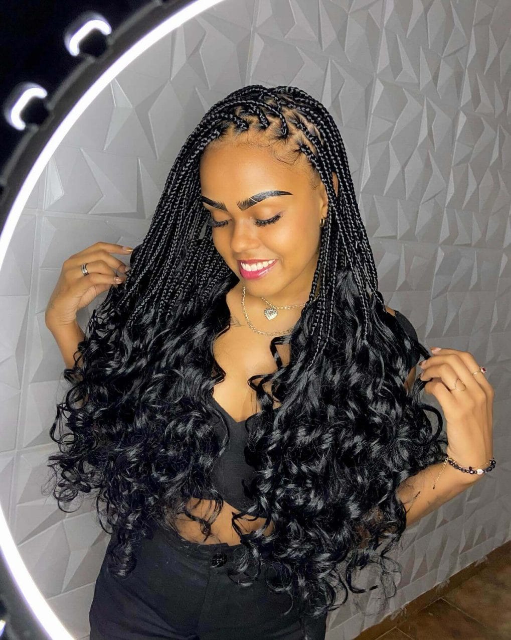 Luxurious waves emerge from symmetrical scalp braids in classic black