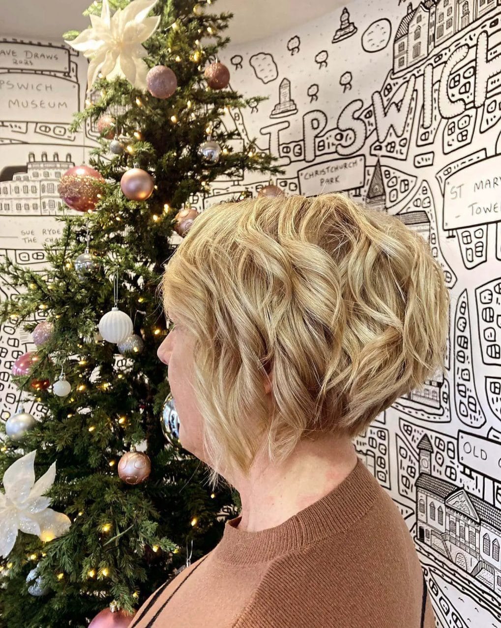 Textured bob with bouncy curls and honey-platinum blend.
