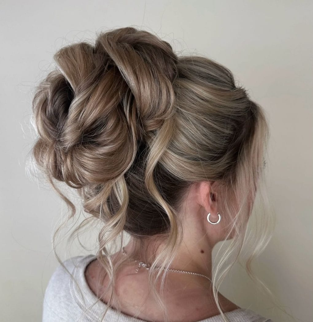 Multi-tonal high bun with a mix of tight and loose twirls
