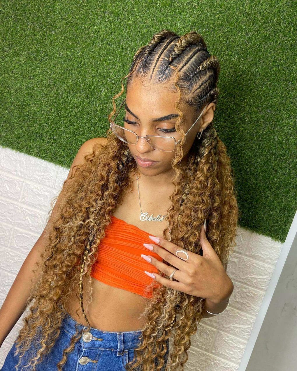 Honey-blonde highlights add warmth to tight cornrows and curly ends