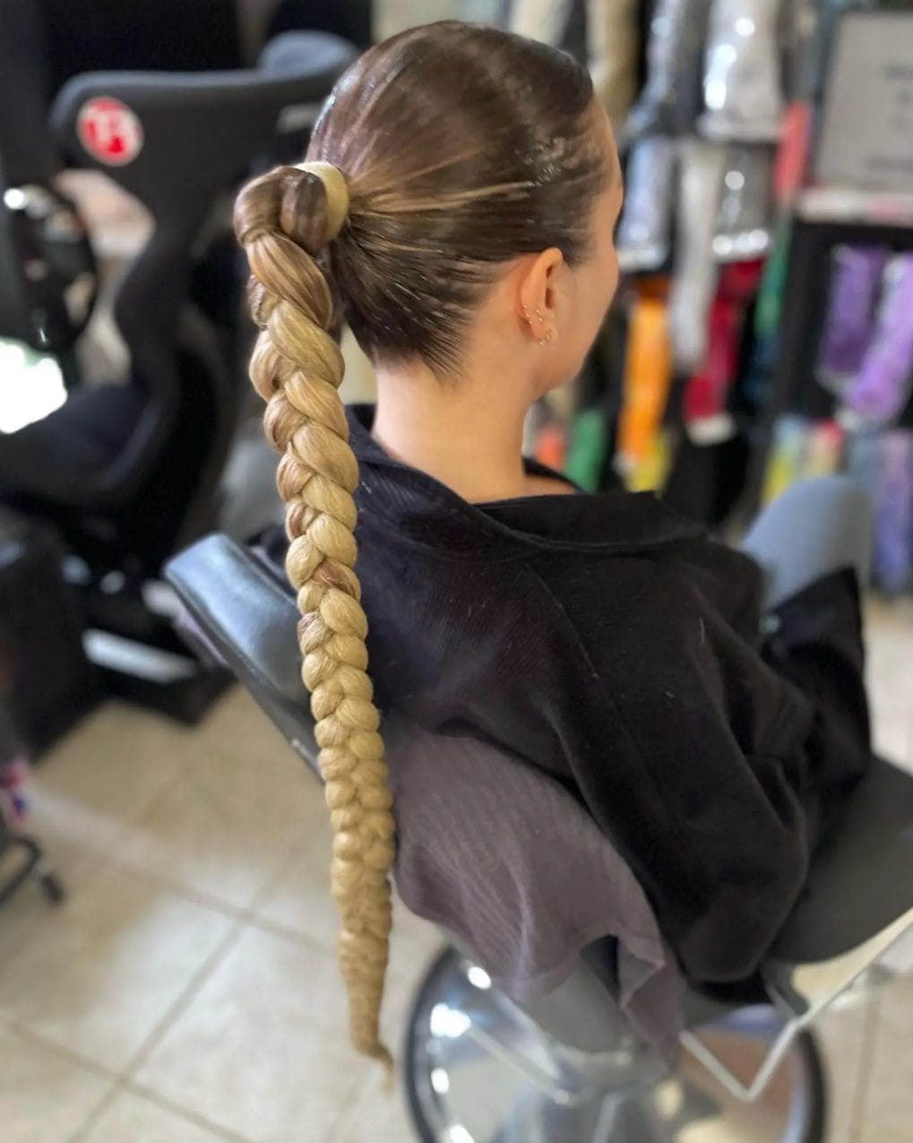 Tight, mixed-shade braid forming a ponytail with a coiled start and thick tail.